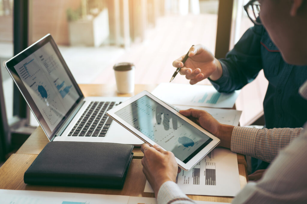 Compañeros de trabajo de la asociación empresarial que utilizan una tableta para trazar el informe de los estados financieros de la empresa y las ganancias, el progreso del trabajo y la planificación en la sala de la oficina